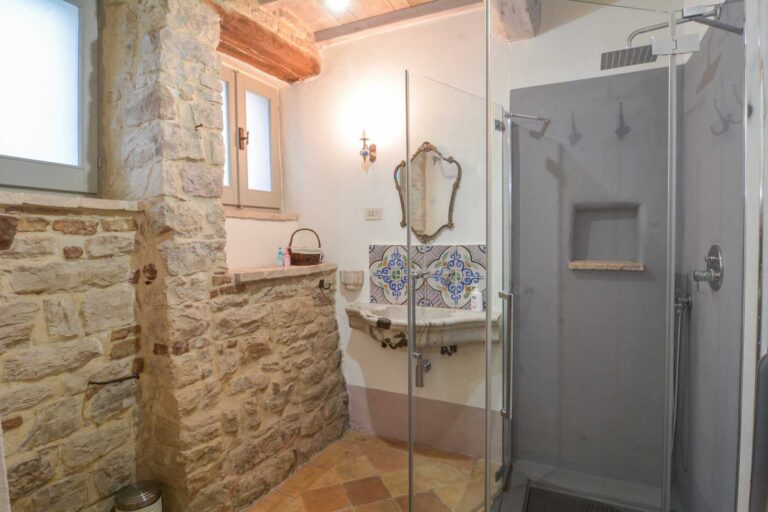 a bathroom with a stone wall and a stone sink at the Alley Cottage